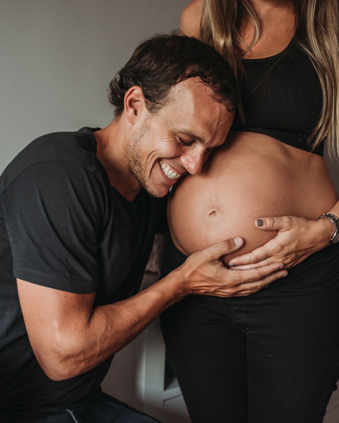 Padre besando la panza de la mamá embarazada