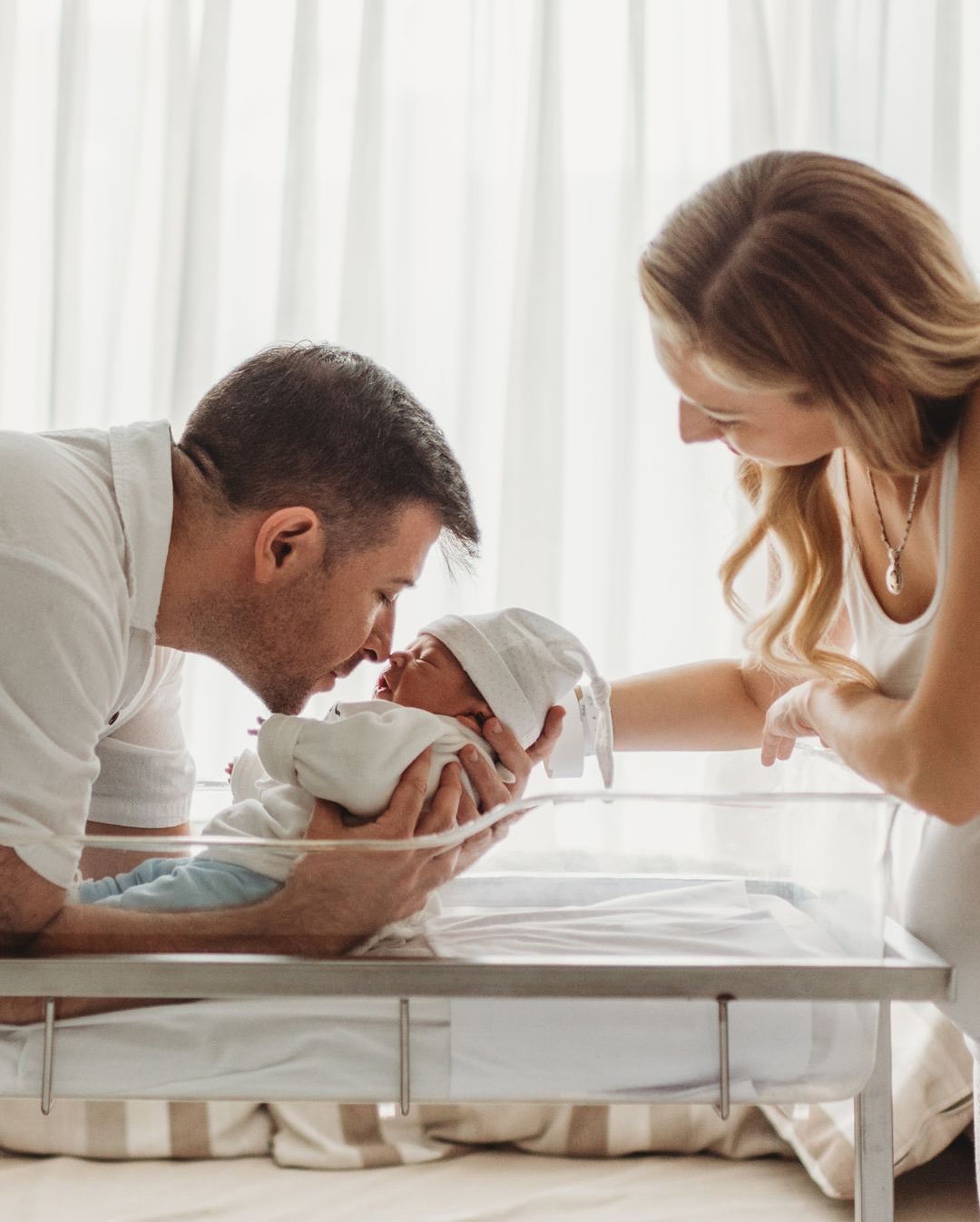 Padres besando a su bebé recién nacido en el hospital